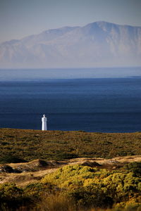 Lighthouse by sea against sky