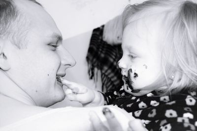 Close-up of father carrying cute daughter with messy face at home