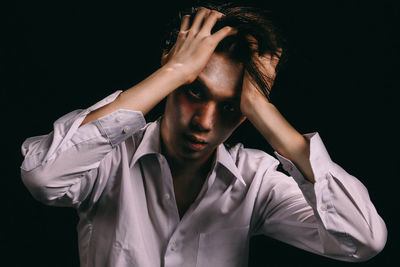 Portrait of young man with halloween make-up against black background