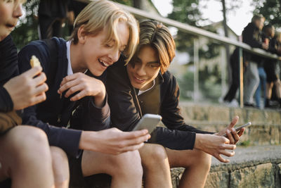 Happy teenage boys sharing smart phone