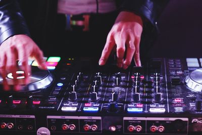 Midsection of man mixing music in recording studio