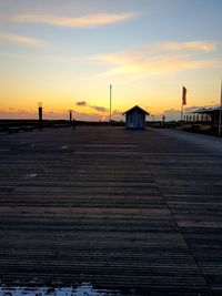 View of footpath by building against sky during sunset