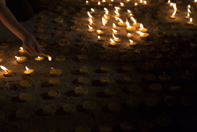 Midsection of person with illuminated candles