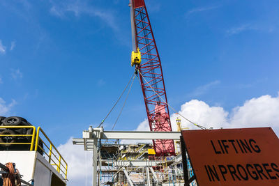 Low angle view of crane against sky