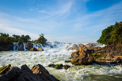 Scenic view of rocks in sea against sky