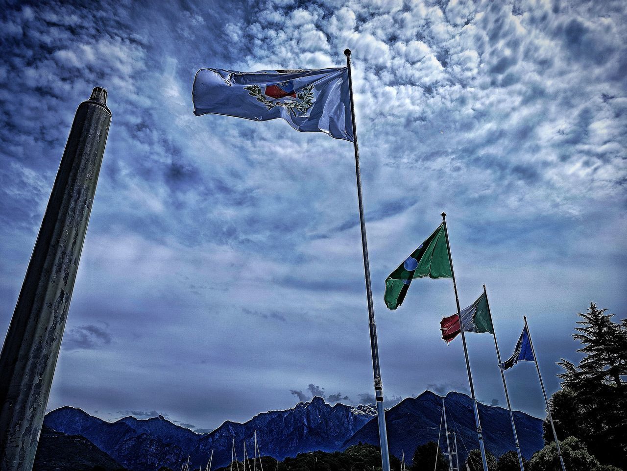 LOW ANGLE VIEW OF FLAG AGAINST CLOUDY SKY