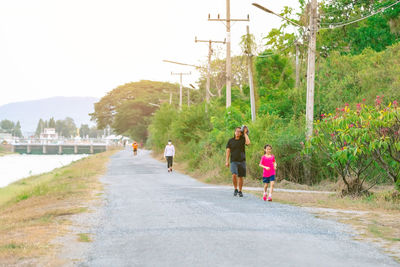 People walking on road against sky