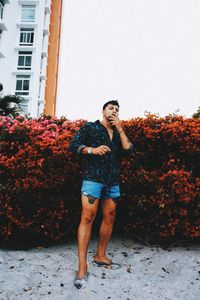 Portrait of young man standing against built structure