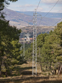 Electricity pylon on land against sky