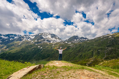 Man standing on mountain by road against sky
