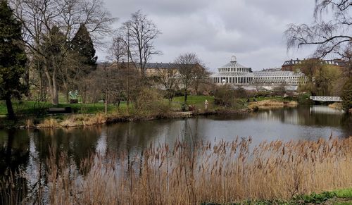Scenic view of lake by buildings against sky