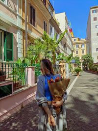 Woman with dog against building