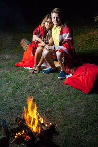 Young couple sitting on bonfire