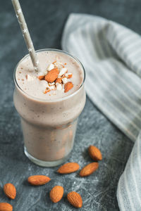 High angle view of drink in glass with almonds on table