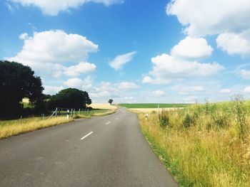 Empty road along trees