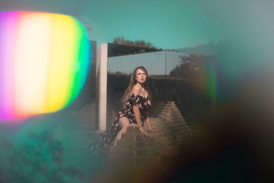 Portrait of smiling young woman standing against blurred background