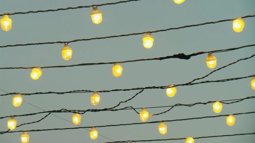 Low angle view of illuminated christmas lights against clear sky