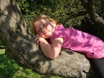 Portrait of smiling girl on tree trunk