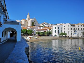 Canal amidst buildings against blue sky