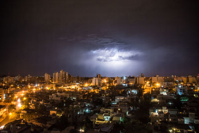 High angle view of illuminated city against sky at night