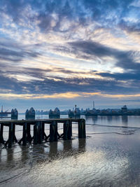 View of river thames against cloudy sky