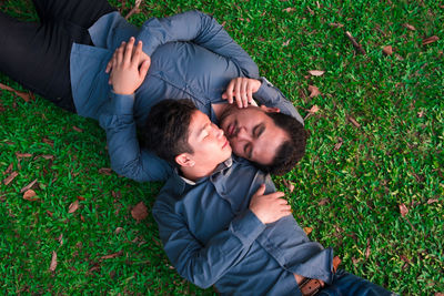 High angle view of happy friends relaxing on field