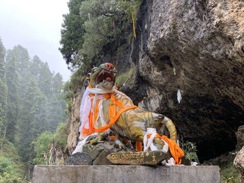 Low angle view of people on rock against sky