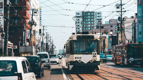Cars on street in city against sky