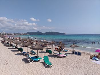 Panoramic view of people on beach against sky