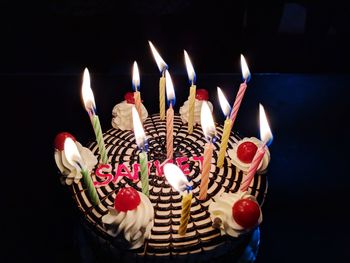 Close-up of illuminated candles against black background