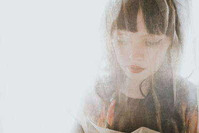 Close-up of beautiful woman at window