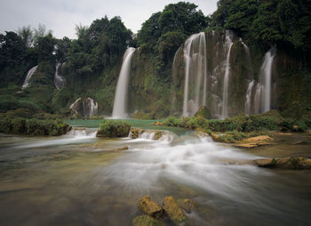 Scenic view of waterfall against sky