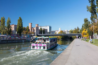 View of city at waterfront against blue sky