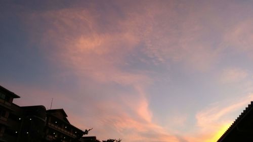 Low angle view of silhouette buildings against sky at sunset