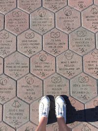 Low section of woman standing on tiled floor