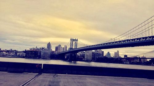 View of bridge and cityscape against sky during sunset