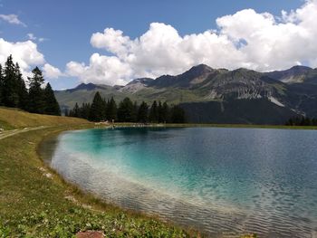 Scenic view of lake by mountains against sky