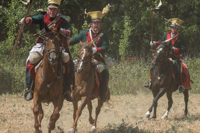 People riding horses on field