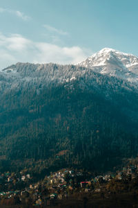 Aerial view of townscape and mountains against sky