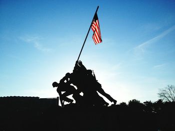 Silhouette of statues with american flag