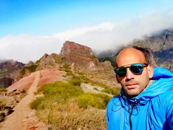 Portrait of man wearing sunglasses against mountain