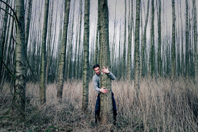 Man hugging tree in forest