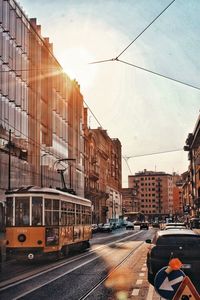 Railroad tracks in city against sky