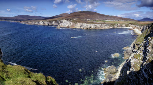 Scenic view of sea and mountains against sky