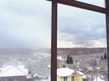 Houses in town against sky during winter