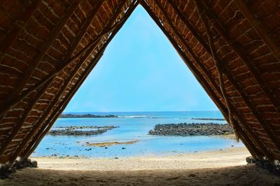 View of built structure on beach against blue sky