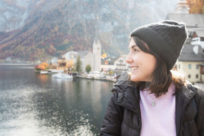 Portrait of young woman looking away against lake