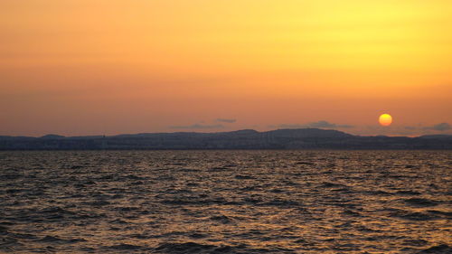 Scenic view of sea against orange sky