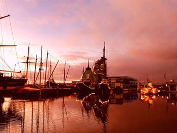 Boats moored at harbor against sky during sunset