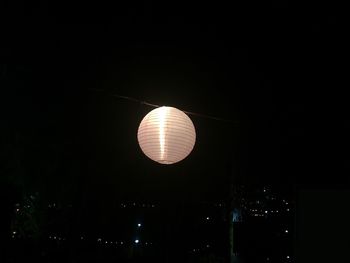 Low angle view of illuminated lights against sky at night